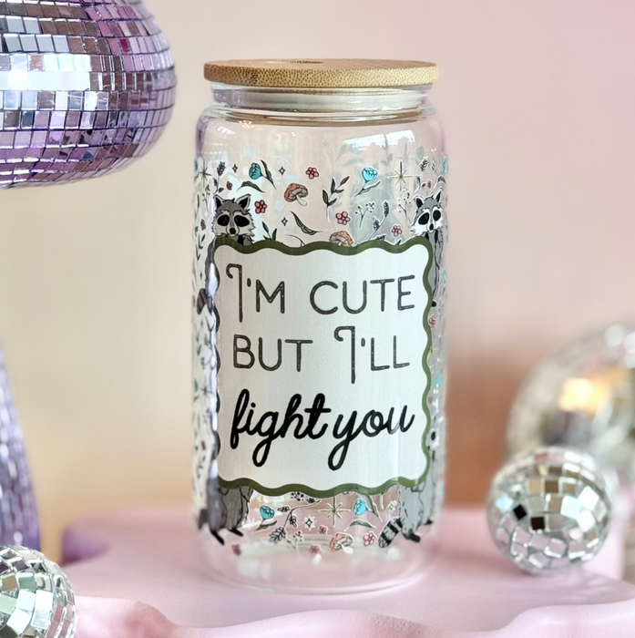 Decorative jar with a humorous message surrounded by disco balls and a mirror ball on a pink platform.