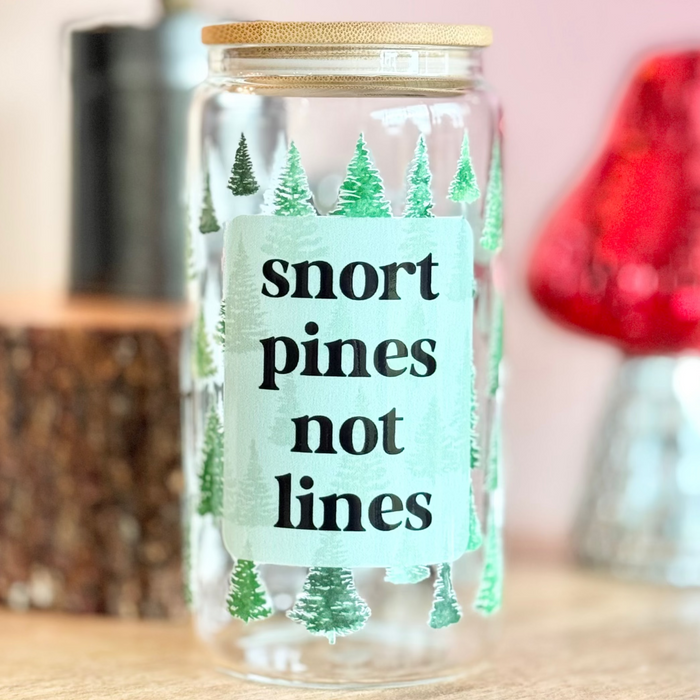 Glass jar with a humorous label on a wooden surface with decorative items in the background