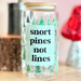 Glass jar with a humorous label on a wooden surface with decorative items in the background