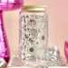 Decorative jar with floral design on a pink background with disco ball and string lights.